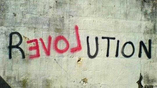 The word Revolution painted on a concrete wall, with Love written in red across the middle letters